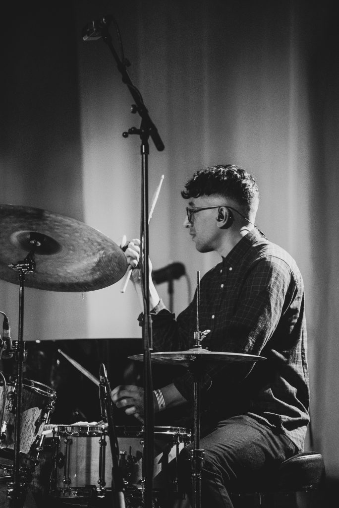 Alan Taylor playing drums on stage